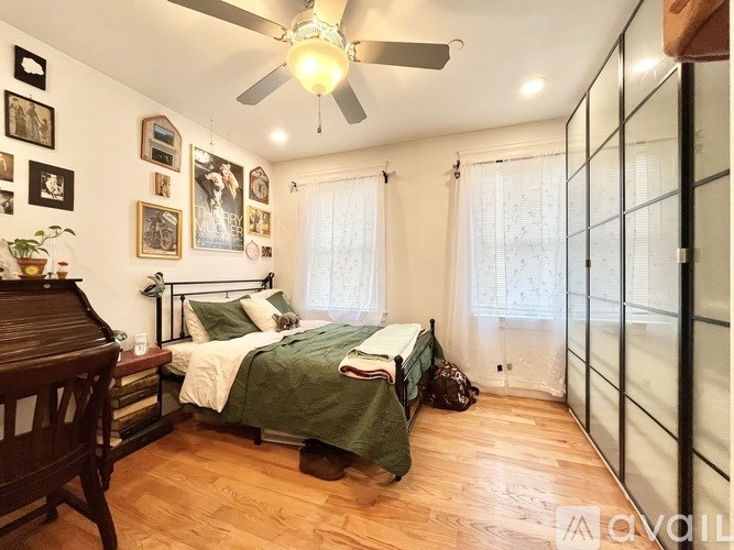 A bedroom with a bed, a chair, and pictures on the wall.