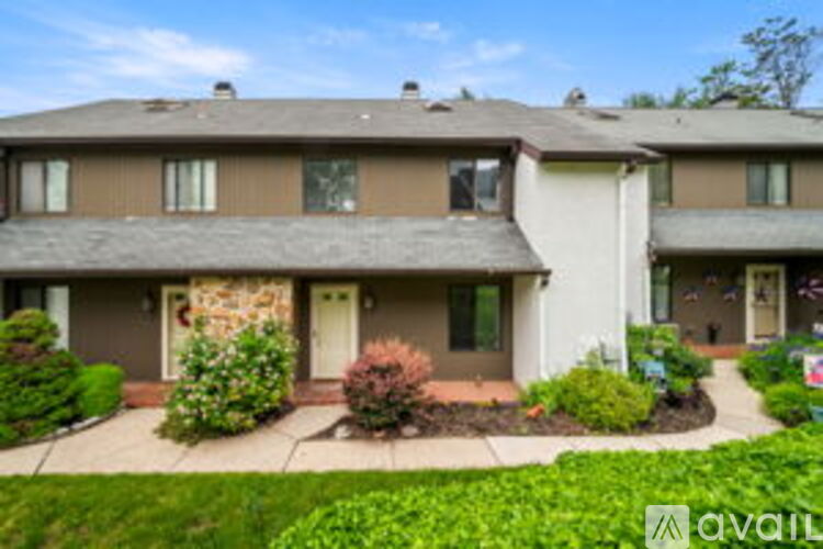 A house with a brown roof and a white door is available for rent.