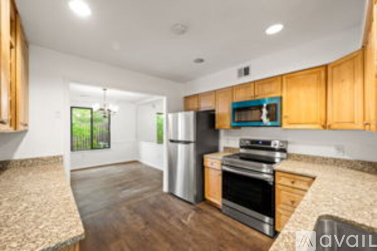 A kitchen with wooden cabinets and a stainless steel refrigerator.