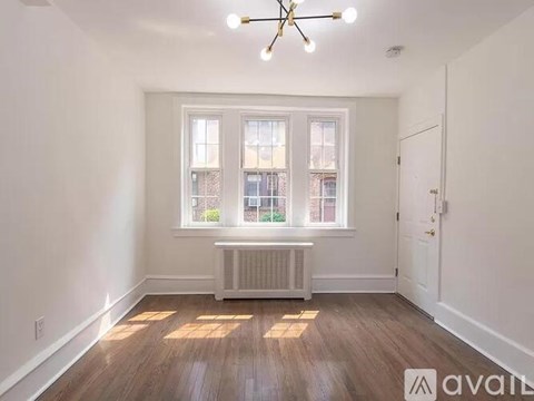 A room with a window and a radiator on the floor.