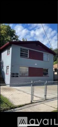 A house with a red roof and a white fence.