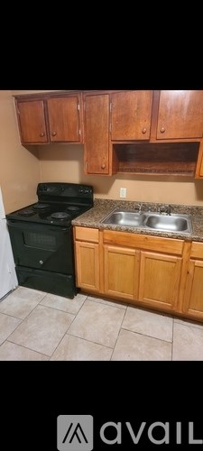A kitchen with wooden cabinets and a black stove top oven.