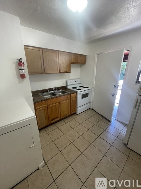 A kitchen with wooden cabinets and a black dishwasher.