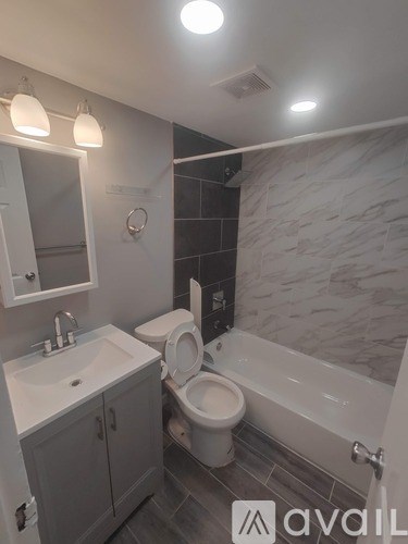 A bathroom with a toilet, sink, and tub.