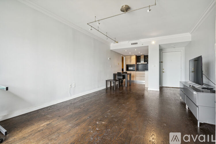 A spacious living room with hardwood floors and a television.