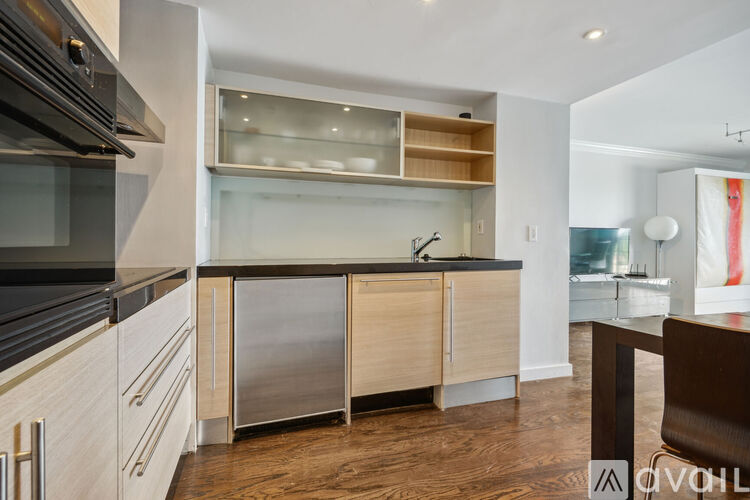 A modern kitchen with wooden cabinets and a black countertop.