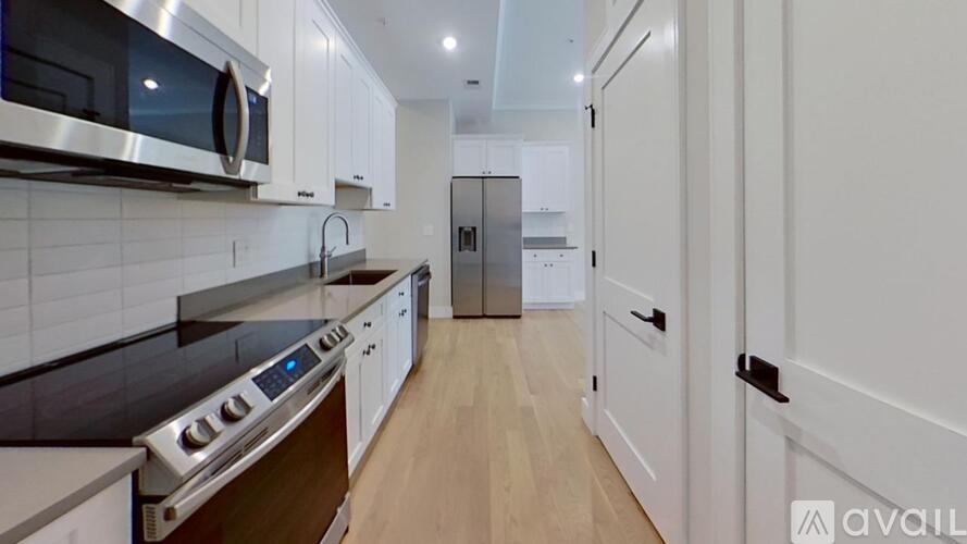 A modern kitchen with white cabinets and a stainless steel oven.