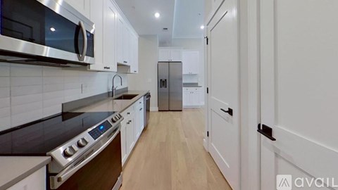 A modern kitchen with white cabinets and a stainless steel oven.