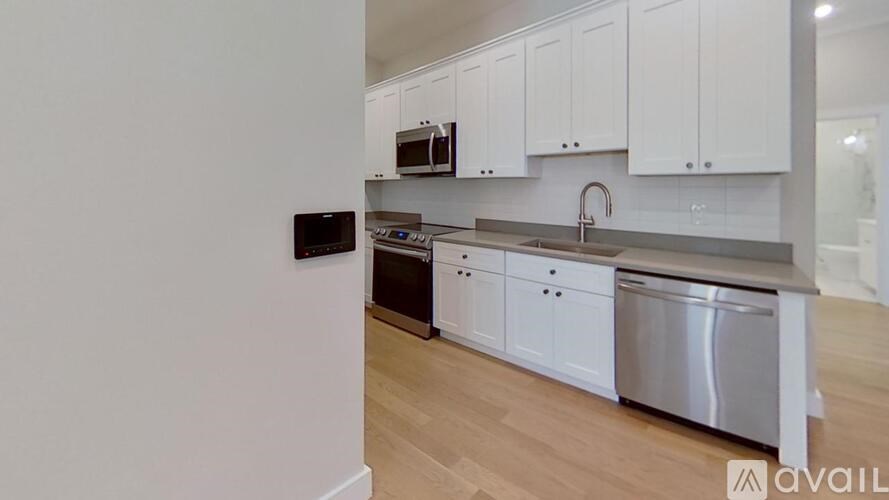 A kitchen with white cabinets and a stainless steel dishwasher.