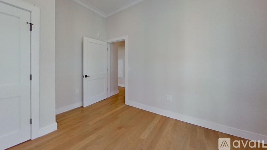 A room with wooden flooring and white walls.