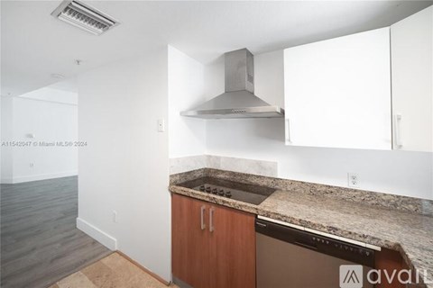 A kitchen with a brown countertop and a stainless steel range hood.