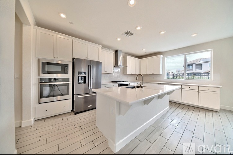 A modern kitchen with a large island and stainless steel appliances.
