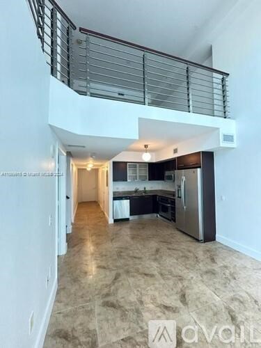 A spacious kitchen with a refrigerator, sink, and stove is located in the open floor plan of a modern home.