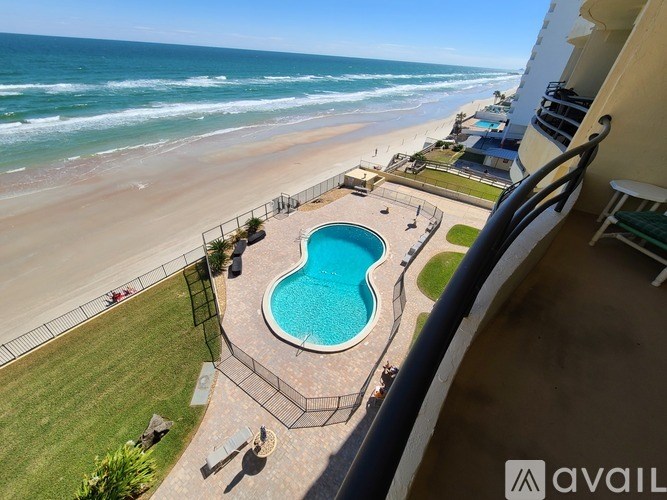 A beachfront property with a pool and a view of the ocean.