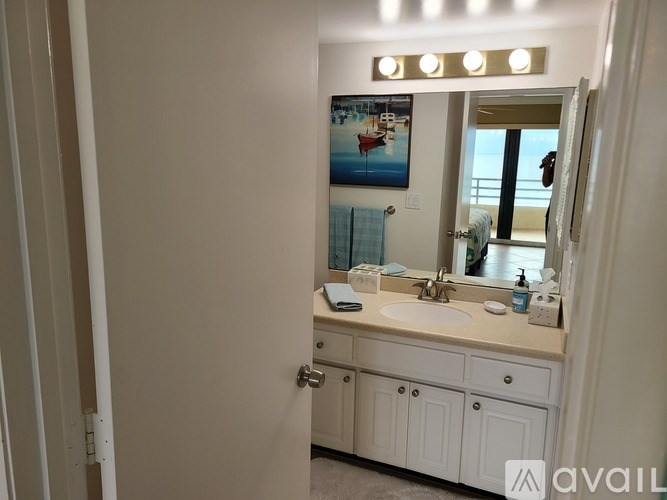 A bathroom with a white vanity and a mirror above it.