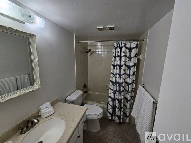 A bathroom with a toilet, sink, and shower.