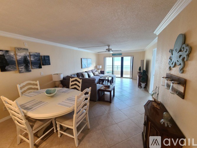 A dining room with a table set for four and a couch.