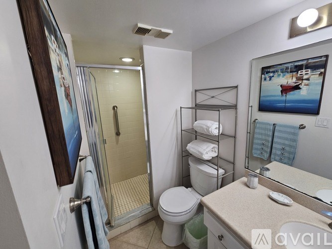 A bathroom with a toilet, sink, and shower.