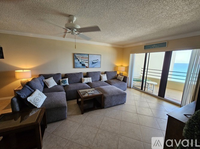 A living room with a grey couch and a ceiling fan.