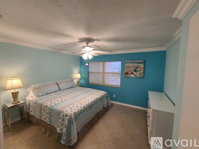 A bedroom with a bed, a ceiling fan, and a window.