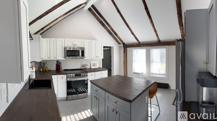 A kitchen with white cabinets and a wooden countertop.