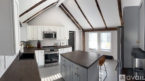 A kitchen with white cabinets and a wooden countertop.