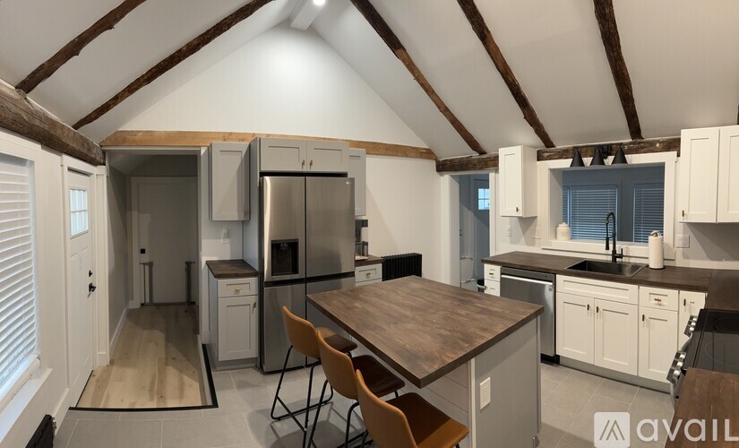 A kitchen with a wooden table and chairs in the middle of the room.