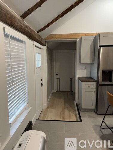 A kitchen with a washing machine in the foreground.