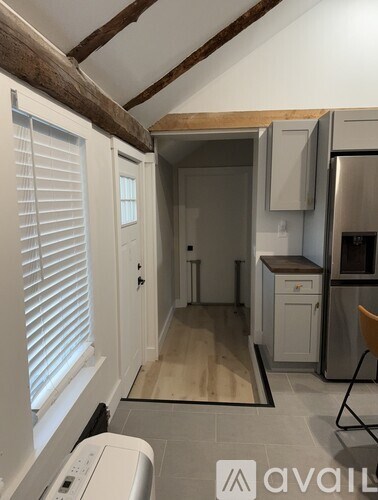 A kitchen with a washing machine in the foreground.