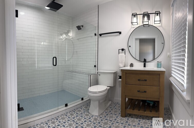 A bathroom with a toilet, a mirror, and a shower.