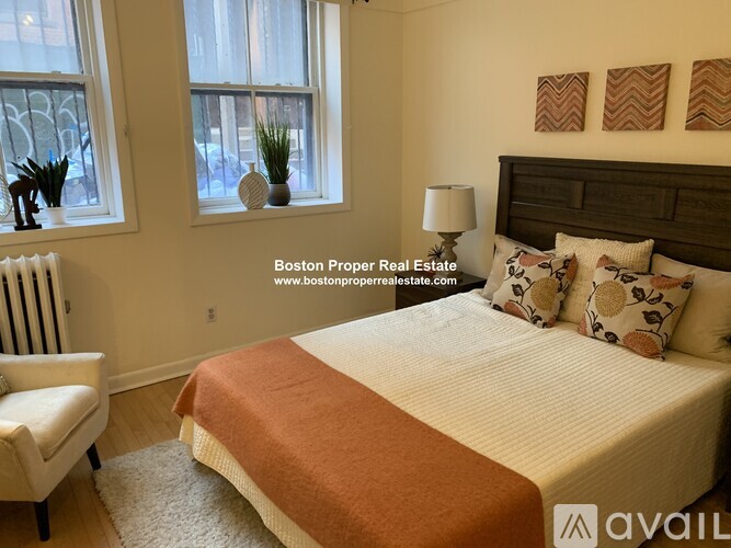 A bedroom with a large bed and a window with a view of a city.