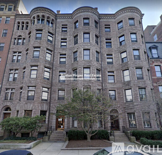 A large, multi-story building with a stone facade and multiple windows.
