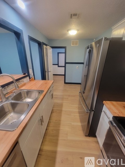 A kitchen with a sink and refrigerator.