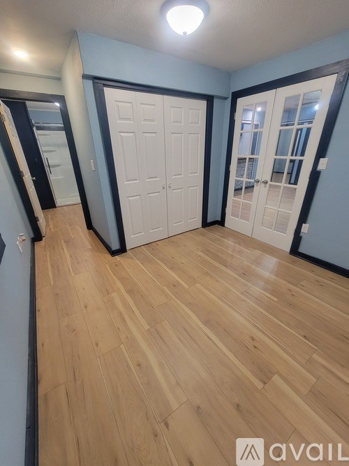 A room with wooden flooring and white doors.