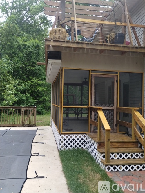 A patio area with a deck and a screened in area.