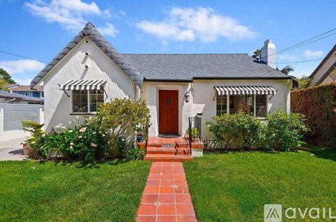 A house with a red door and a brick pathway leading to it.