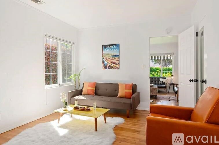 A living room with a grey couch, orange armchair, and a coffee table.