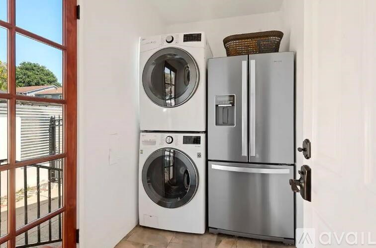 A modern kitchen with a washing machine and a refrigerator.