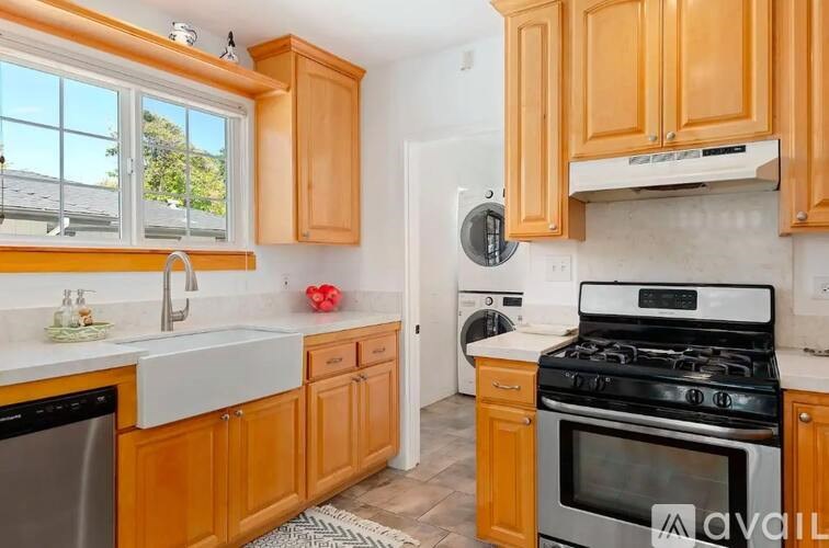 A kitchen with wooden cabinets and a black stove top oven.