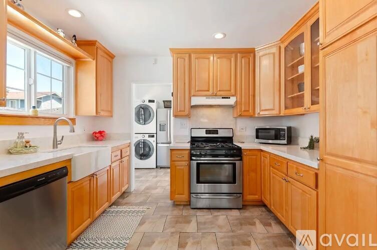 A kitchen with wooden cabinets and a black dishwasher.