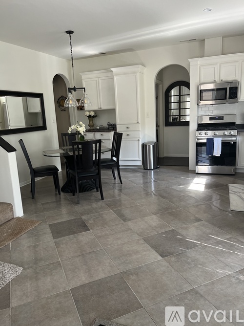 A kitchen with a dining table and chairs.