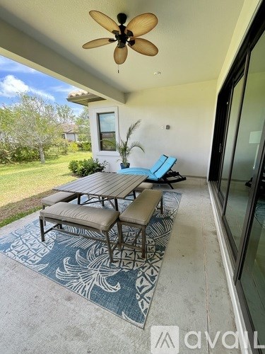 A patio with a table and chairs and a ceiling fan.