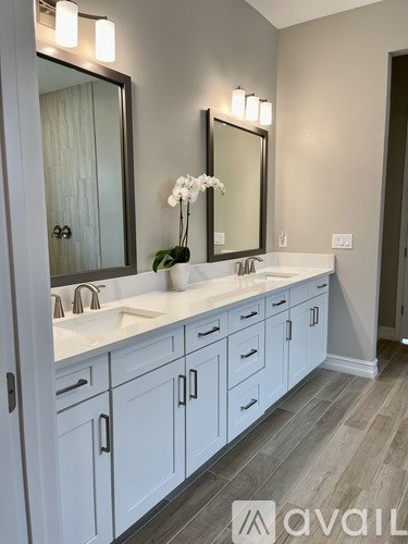 A bathroom with two sinks and a large mirror.
