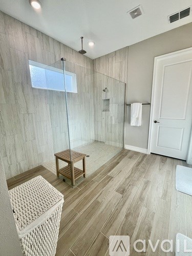 A bathroom with a walk-in shower and a wooden floor.