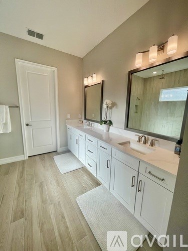 A bathroom with a vanity, mirror, and lighting fixtures.
