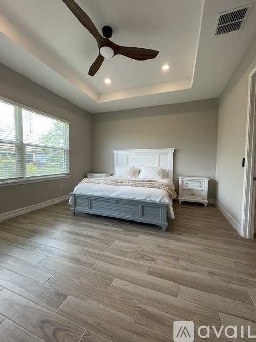 A bedroom with a bed, nightstand, and a ceiling fan.