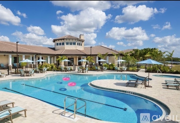 A large outdoor swimming pool with a building in the background.