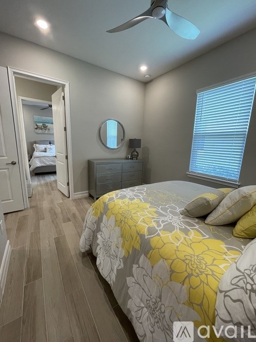 A bedroom with a bed, dresser, and mirror.