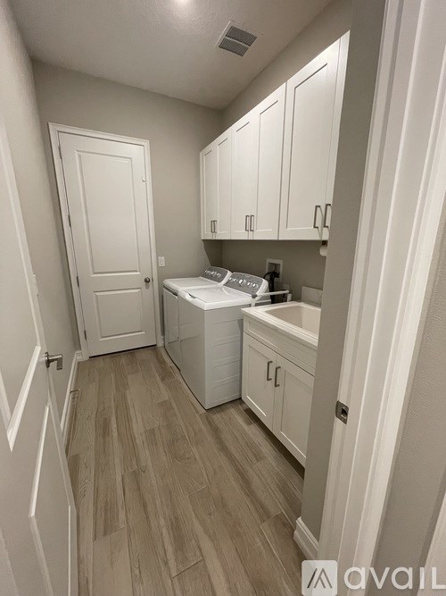 A small kitchen with a white dishwasher and white cabinets.