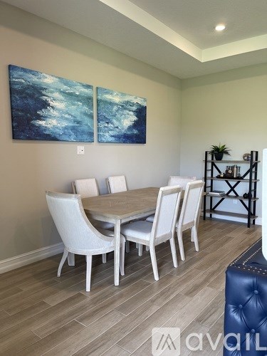 A dining room with a white table and chairs.